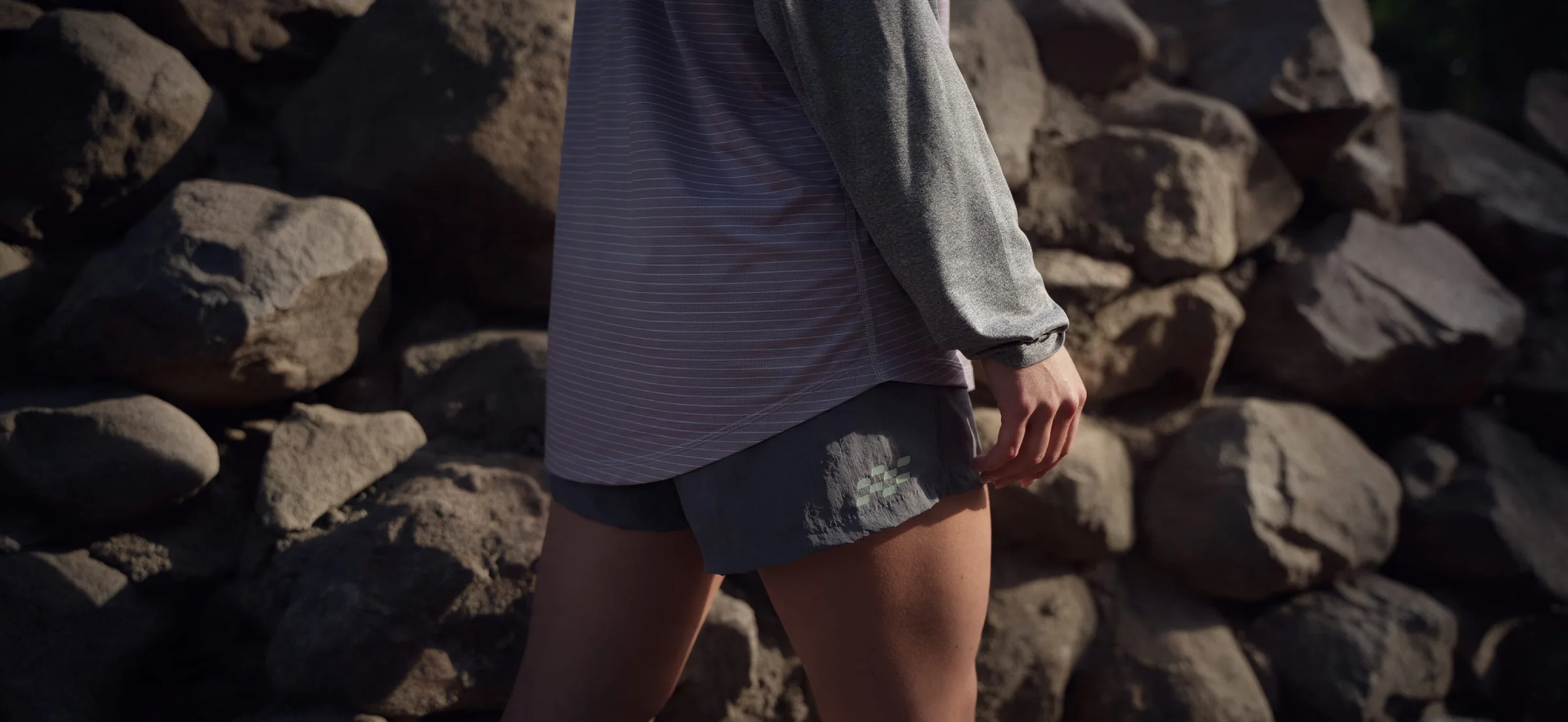 Biegaczka w szortach Full Belt Shorts na tle kamieni