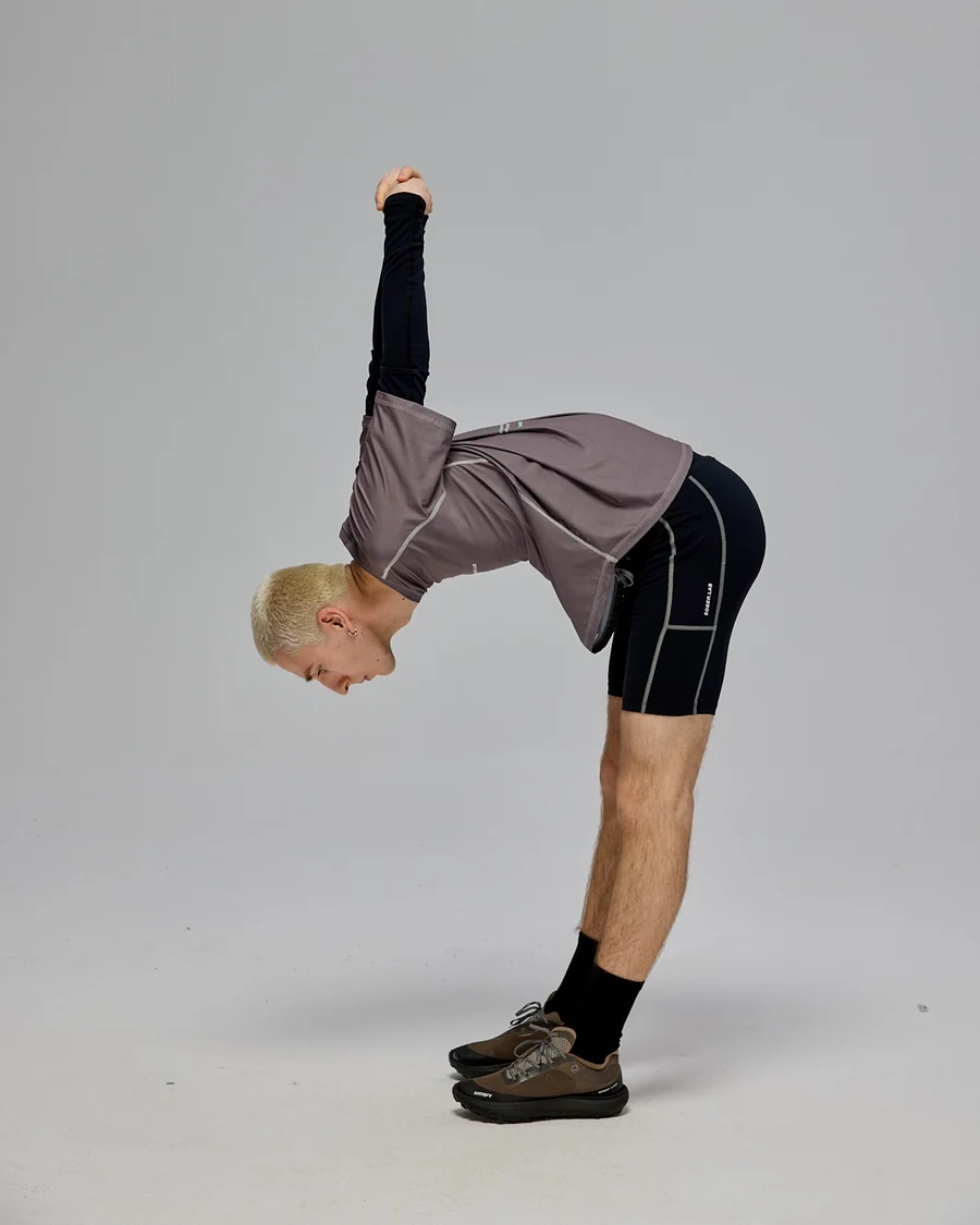 Model w koszulce Light Running Tee Gray Stone i Running Tights w skłonie
