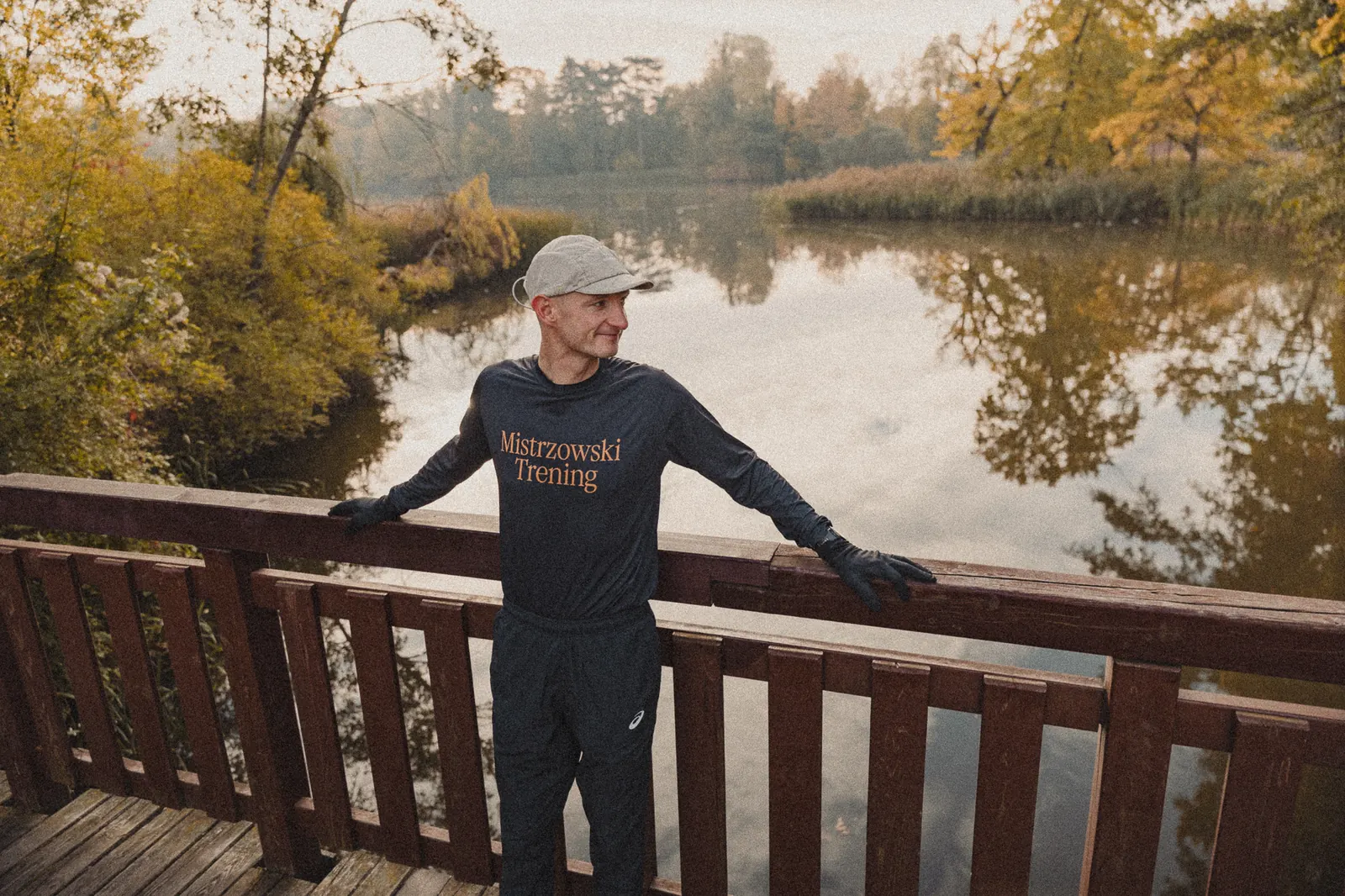 Marcin przy barierce nad stawem jesienią
